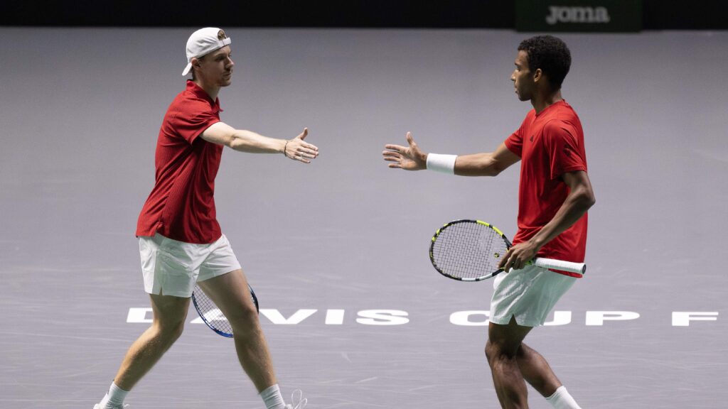 Denis Shapovalov (left) and Felix Auger-Aliassime (right) high five during a doubles win for Canada over Finland at the Davis Cup.