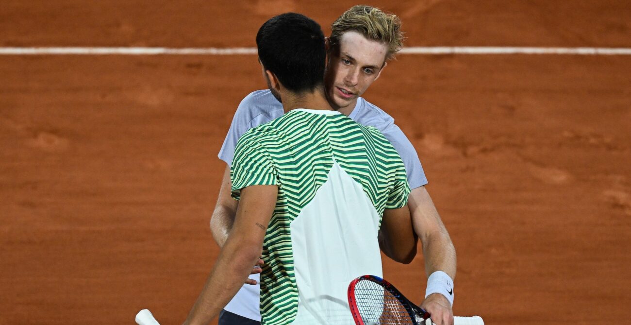 Denis Shapovalov embraces Carlos Alcaraz (back to camera) at Roland-Garros. They will face off on Monday in Indian Wells.