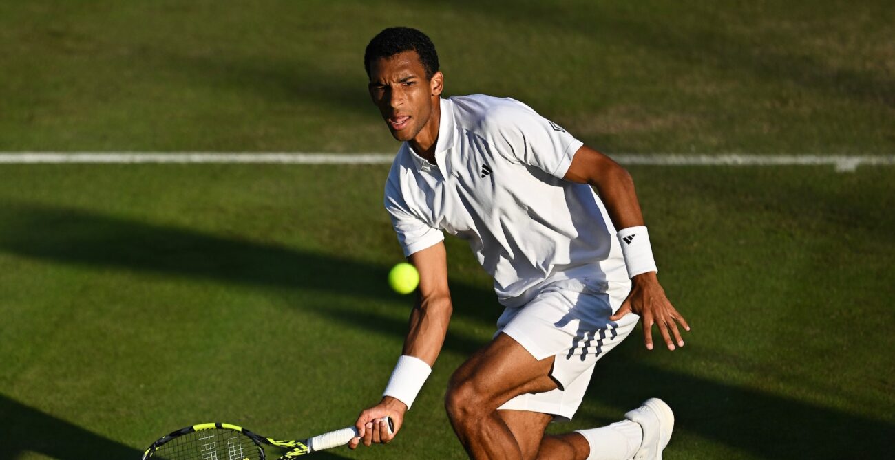 Felix Auger-Aliassime hits a low forehand during his match with Thanasi Kokkinakis at Wimbledon.