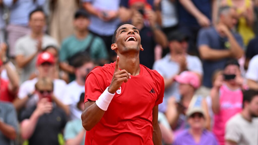 Felix Auger-Aliassime wags a finger at the sky and smiles. He beat Casper Ruud on Thursday at the Olympics.