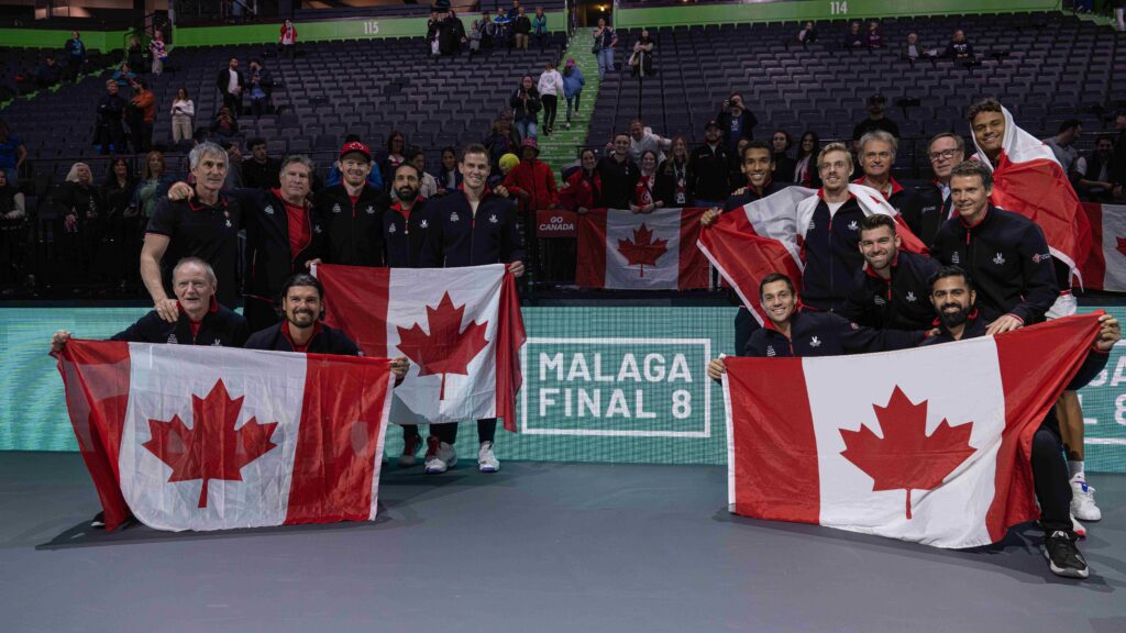 Team Canada poses with flags in front of the fans at the Davis Cup.