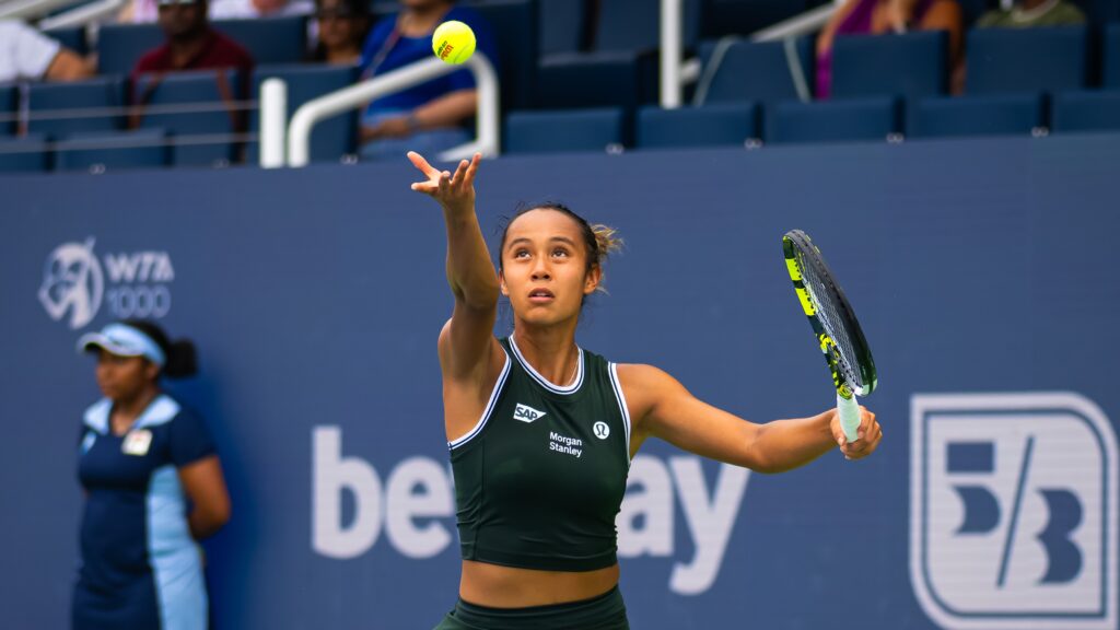 Leylah Fernandez tosses a ball up to serve.