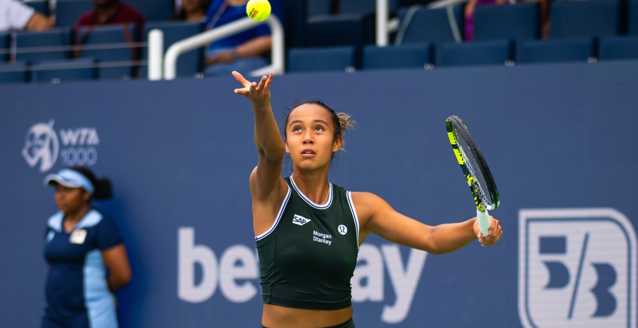 Leylah Fernandez tosses a ball up to serve.