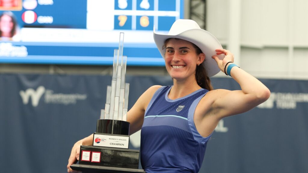 Rebecca Marino tips her cowboy hat while holding her Calgary trophy. She and Kayla Cross were both winners at the ITF event.