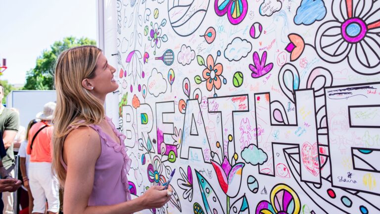 Eugenie Bouchard looks up at the positive court pledge mural.