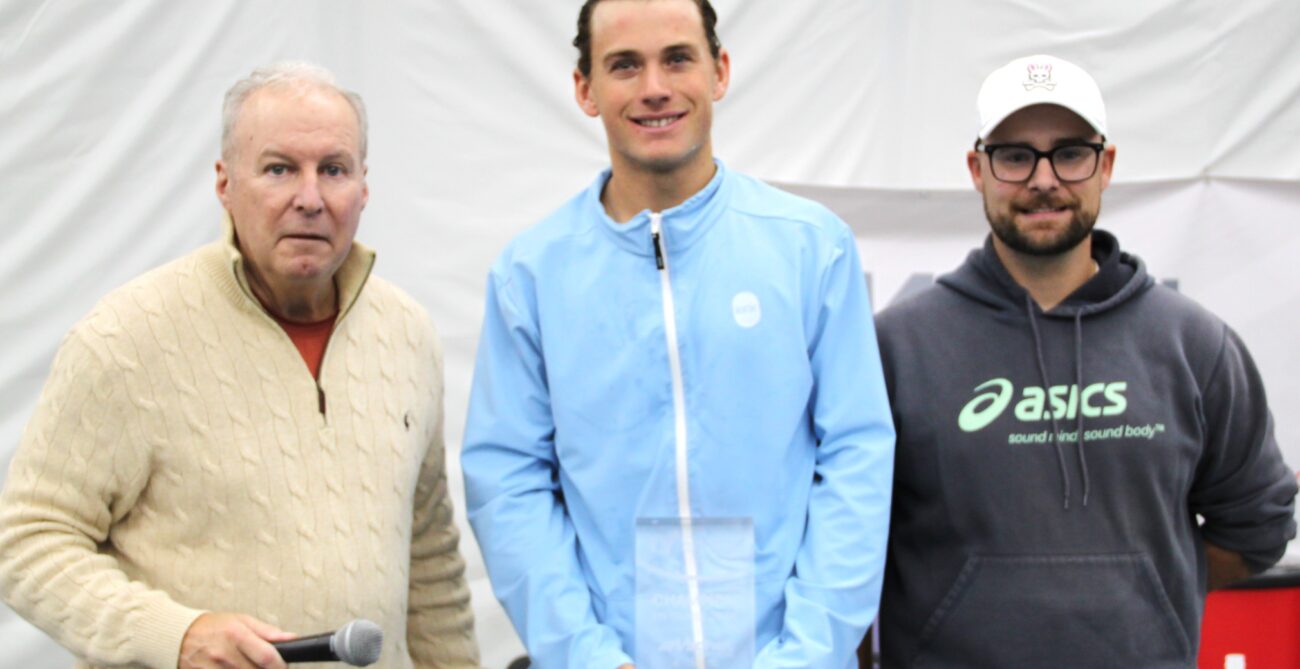 Liam Draxl (centre) holds his trophy after beating Alexis Galarneau in the final of the ITF event in Saint-Augustin.