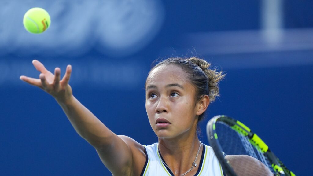 Leylah Fernandez tosses a ball up to serve.