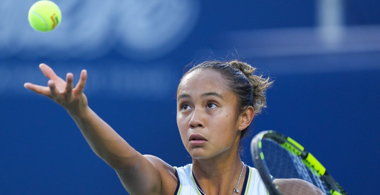 Leylah Fernandez tosses a ball up to serve.