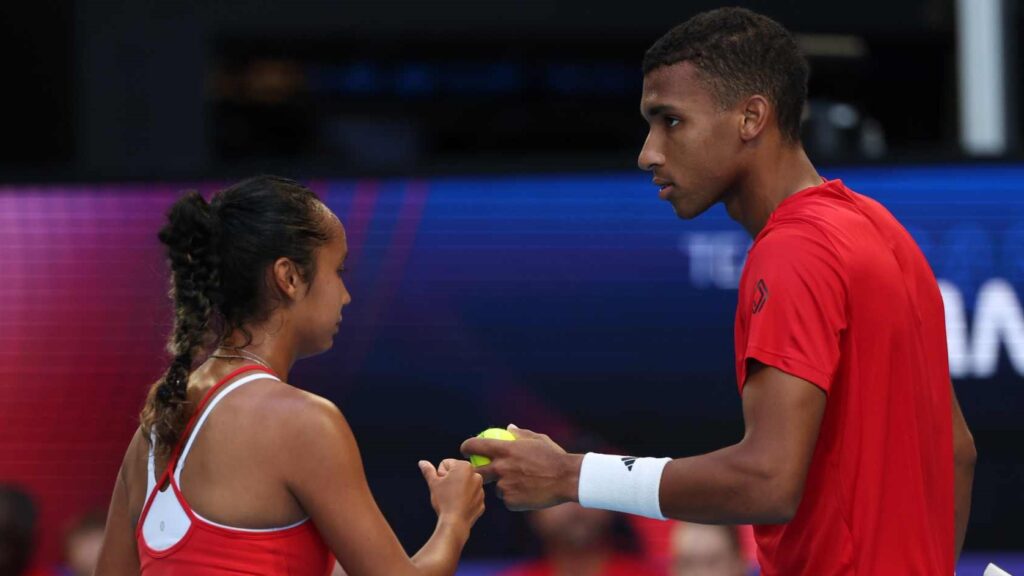 Felix Auger-Aliassime (right) and Leylah Annie Fernandez (left, side to camera) bump fists while representing Canada at the United Cup.