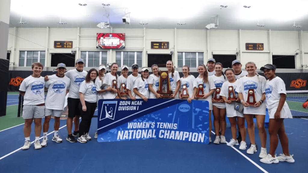 The Texas A&M women's tennis team pose with their trophy and a sign that reads "Women's tennis national champion"