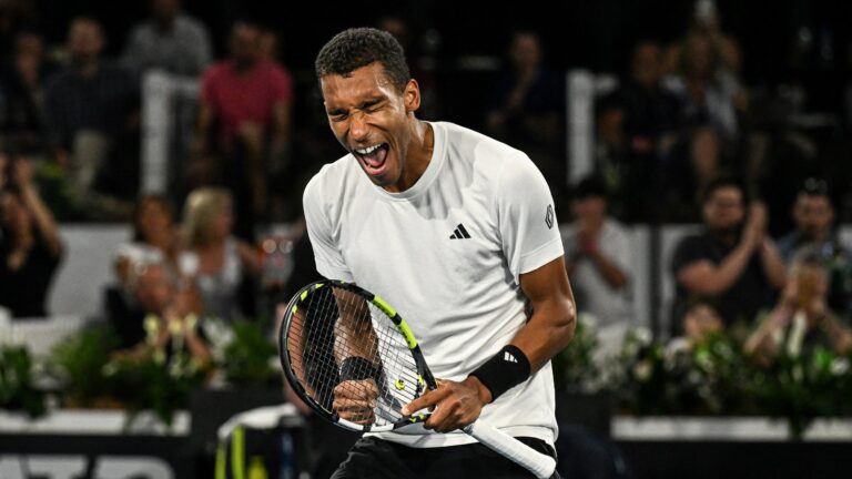 Felix Auger-Aliassime double fist pumps and shouts in celebration. He beat Jan-Lennard Struff on Monday at the Australian Open.