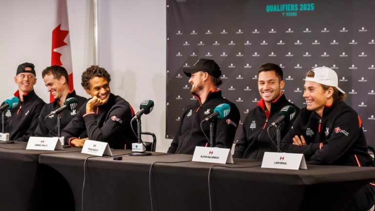 The members of Team Canada at the Davis Cup in Montreal sit at the desks during their pre-event press conference and laugh.