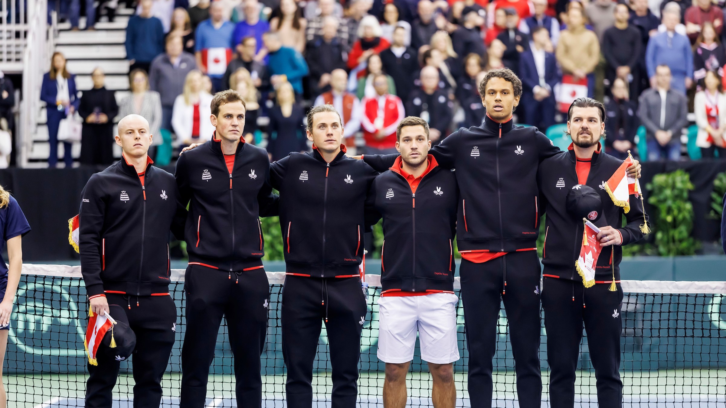 The members of Team Canada stand arm-in-arm on court ahead of their Davis Cup tie with Hungary. From left to right: Cleeve Harper, Vasek Pospisil, Liam Draxl, Alexis Galarneau, Gabriel Diallo, Frank Dancevic.