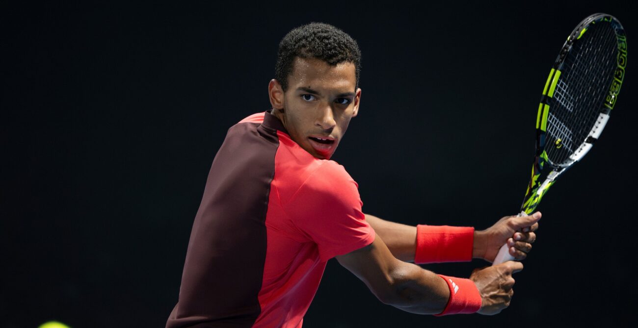 Felix Auger-Aliassime winds up to hit a backhand.