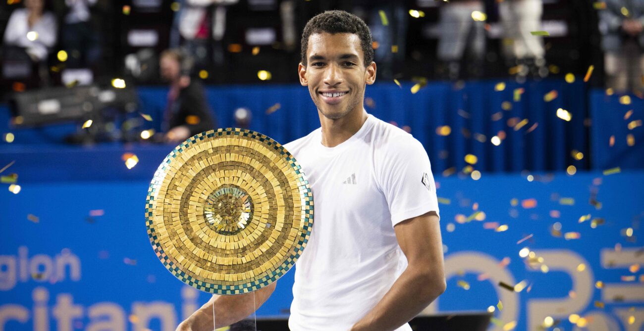 Felix Auger-Aliassime holds up the trophy in Montpellier.