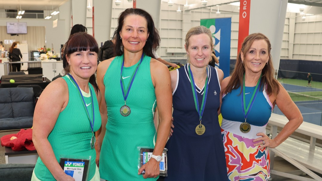 Four women pose with their medals at the Osten & Victor Tennis Centre in Calgary at the 2025 ITF Masters event.